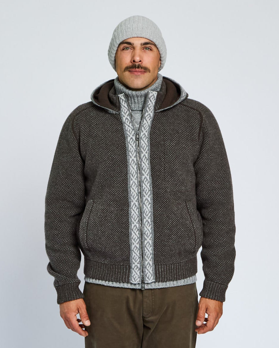 Man wearing a gray knitted hoodie with a zipper on a white background