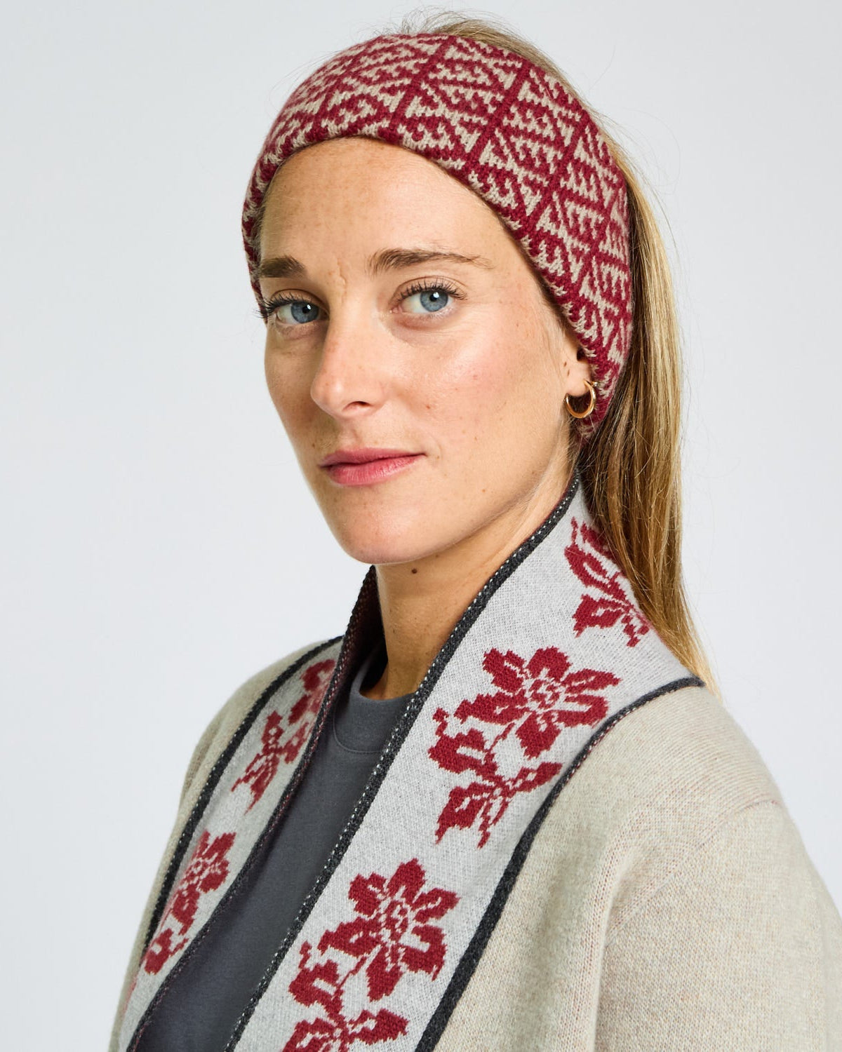 Woman wearing a patterned headband and scarf against a plain background