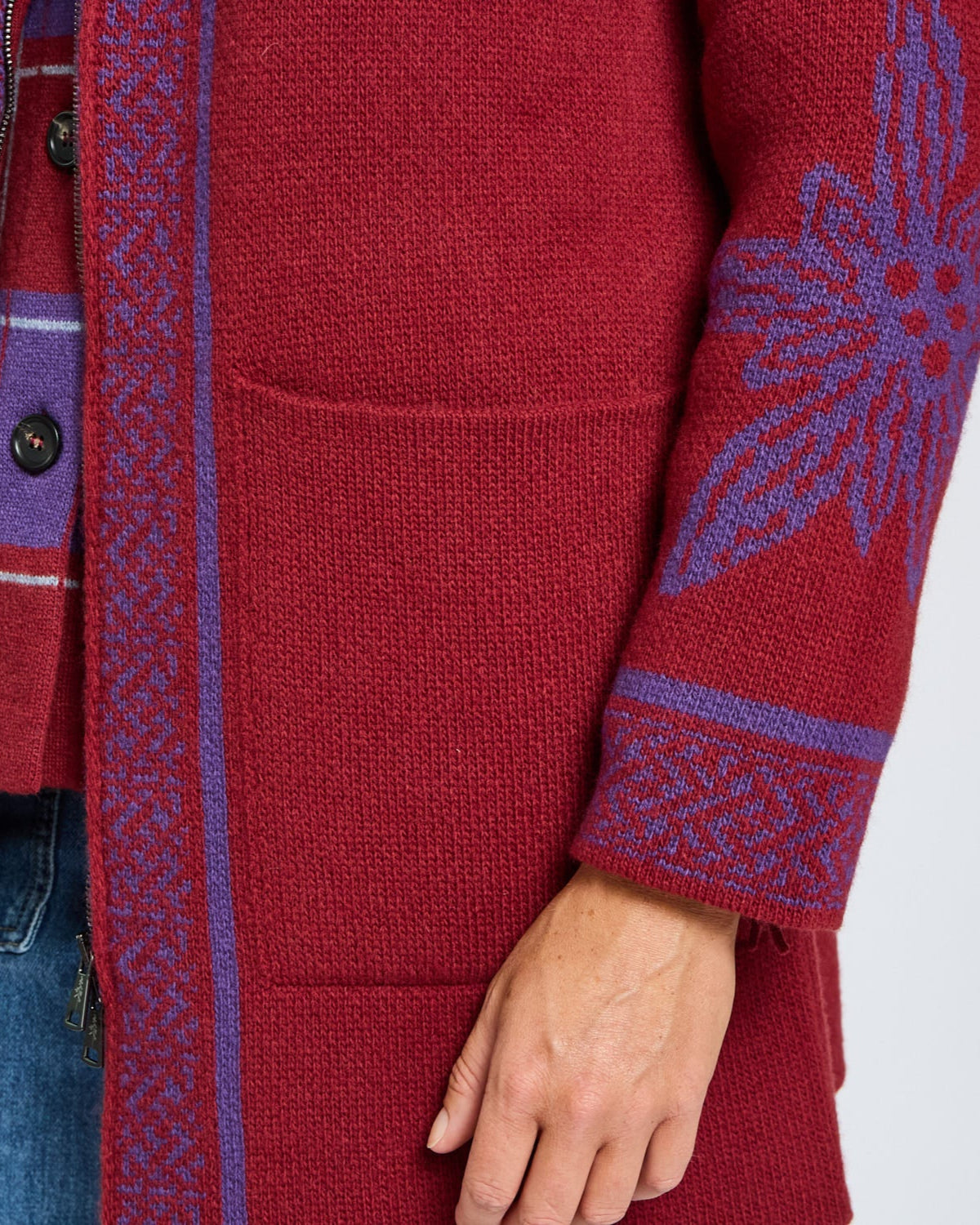 Red cardigan with blue patterned sleeves on a white background