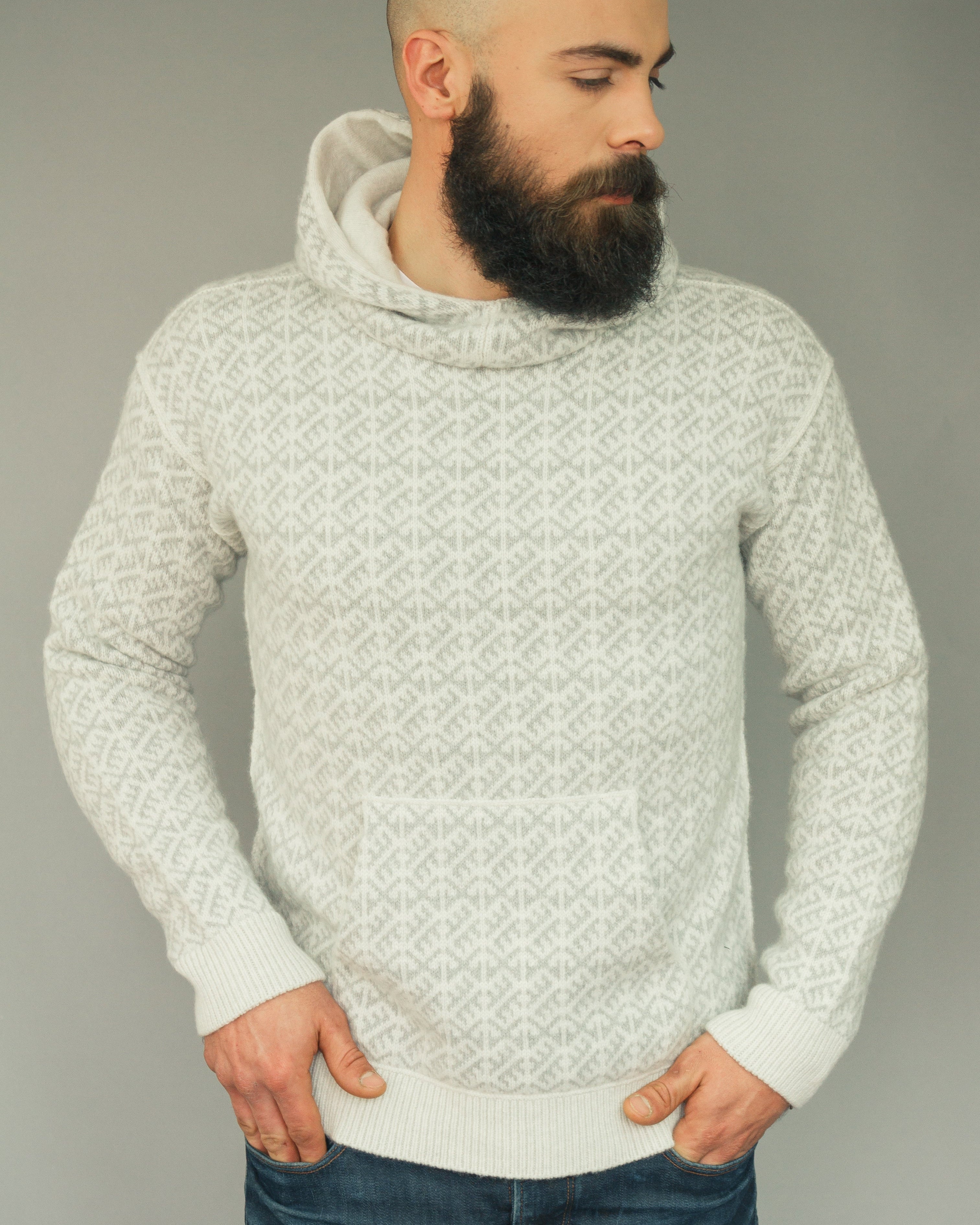 Man wearing a patterned sweater against a plain background