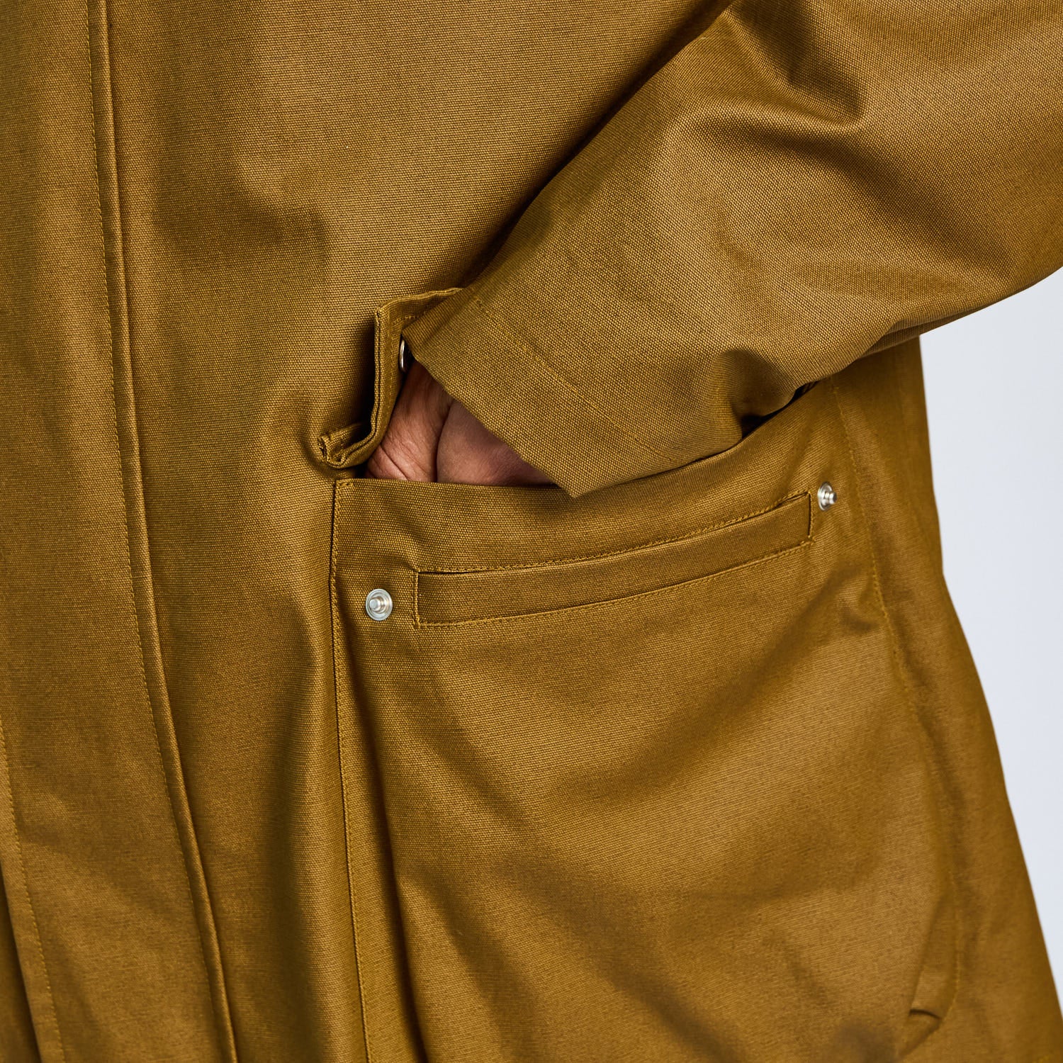Close-up of a brown coat with a pocket on a white background