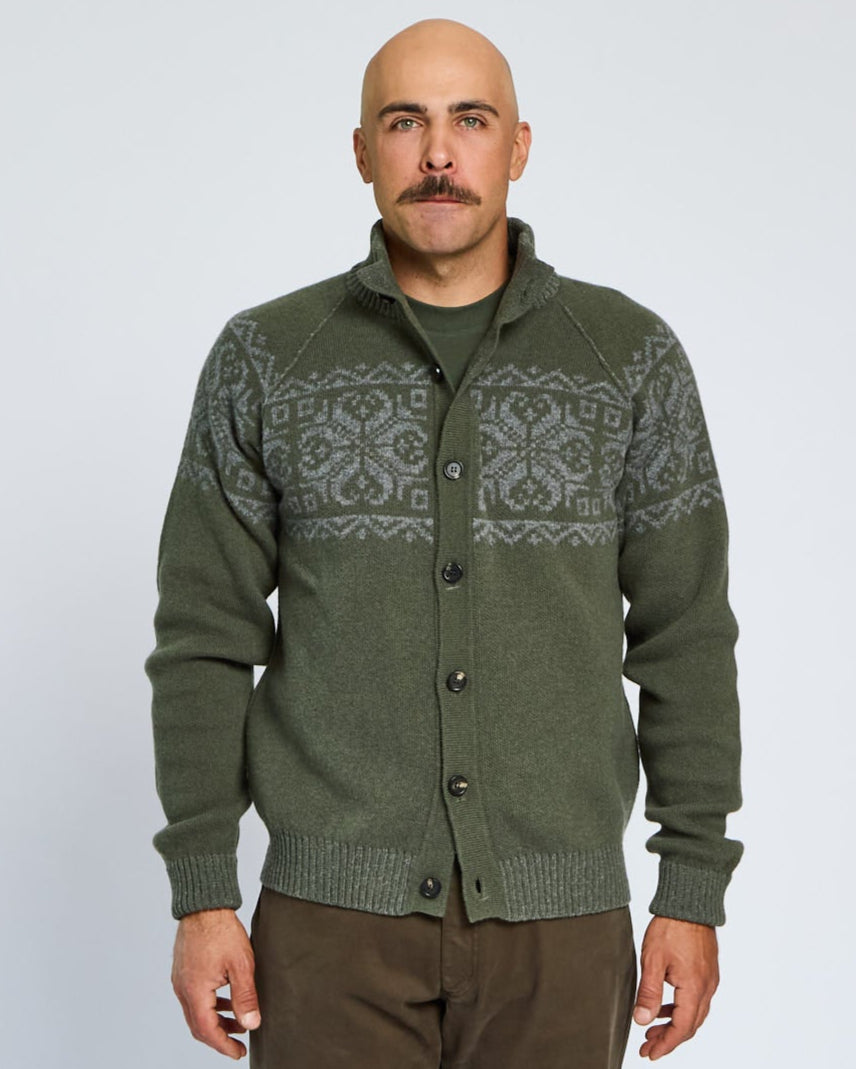 Man wearing a green patterned sweater against a white background