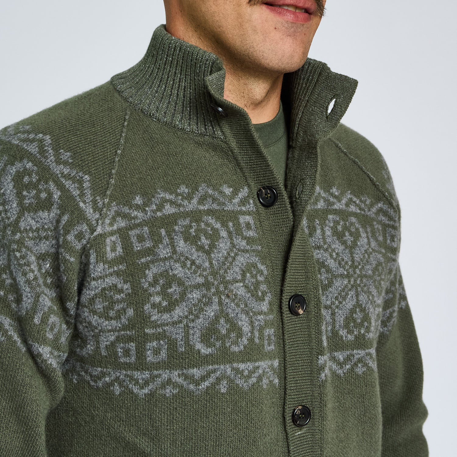 Green knitted cardigan with a patterned design on a plain background