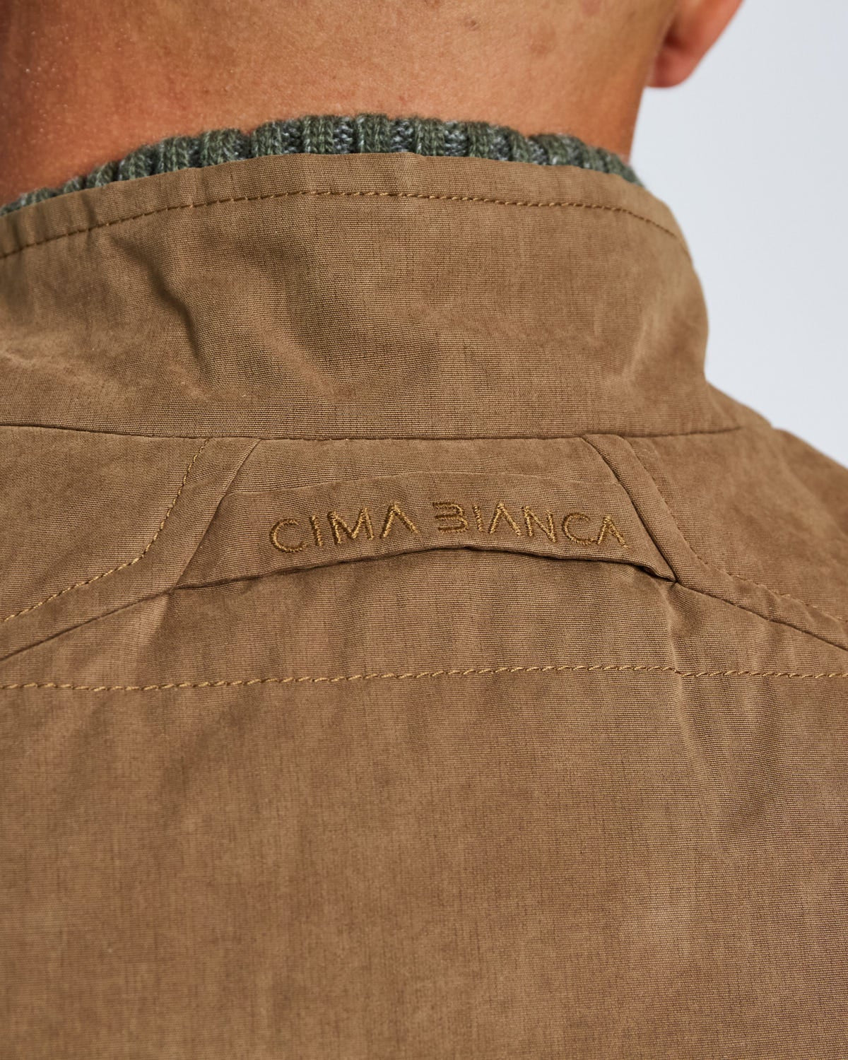 Brown jacket with 'Cima Bianca' branding on a white background