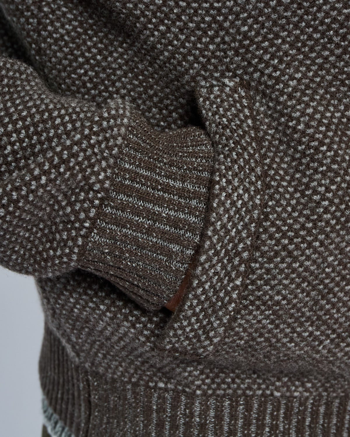 Close-up of a textured brown sweater with a blurred background