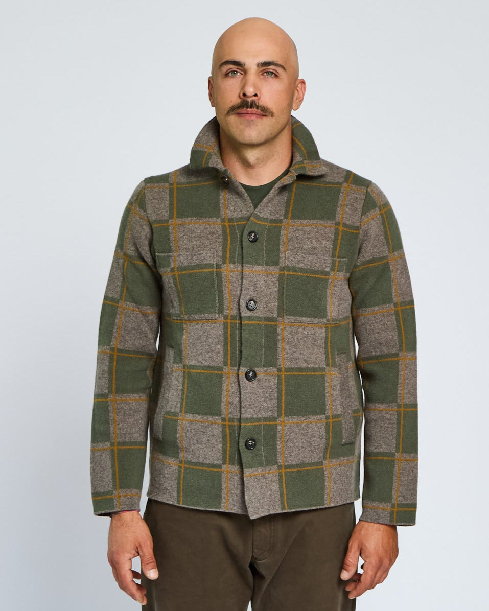 Man wearing a plaid jacket on a plain background