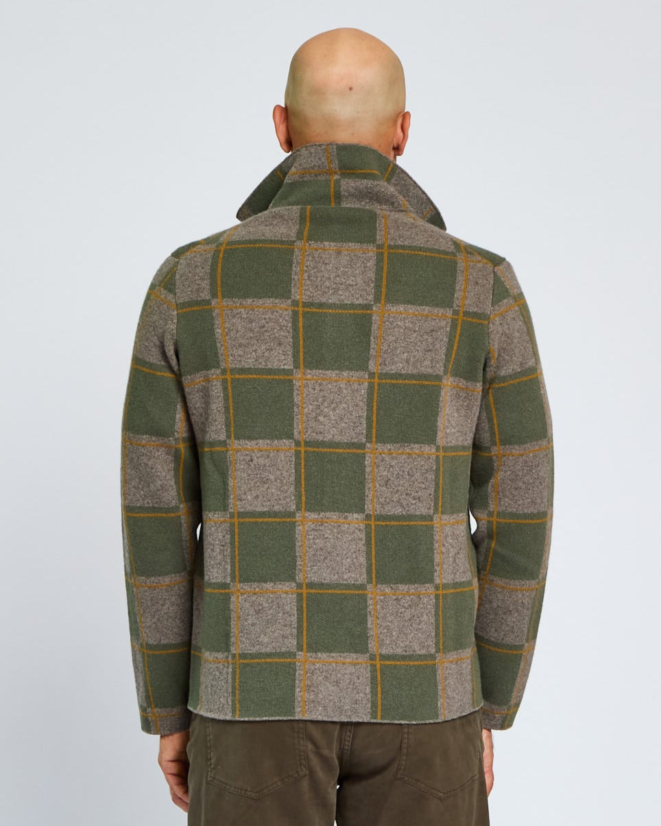 Person wearing a green and brown checkered jacket on a white background