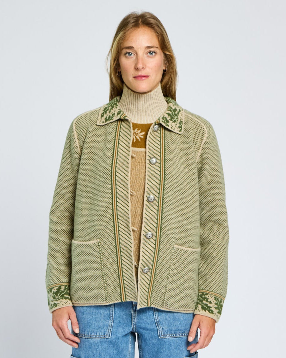 Woman wearing a green patterned jacket on a plain background