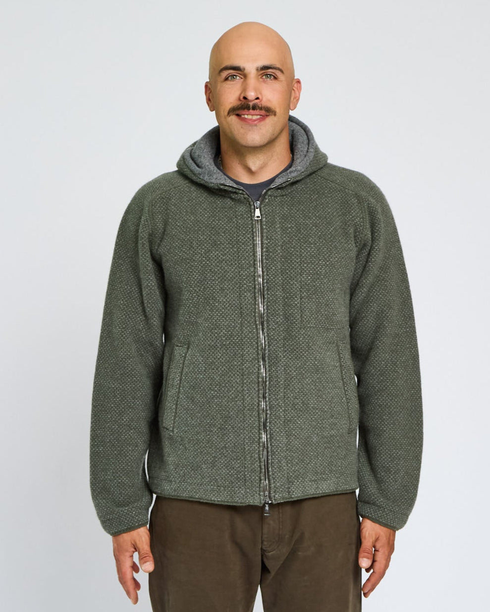 Man wearing a green hooded jacket on a white background