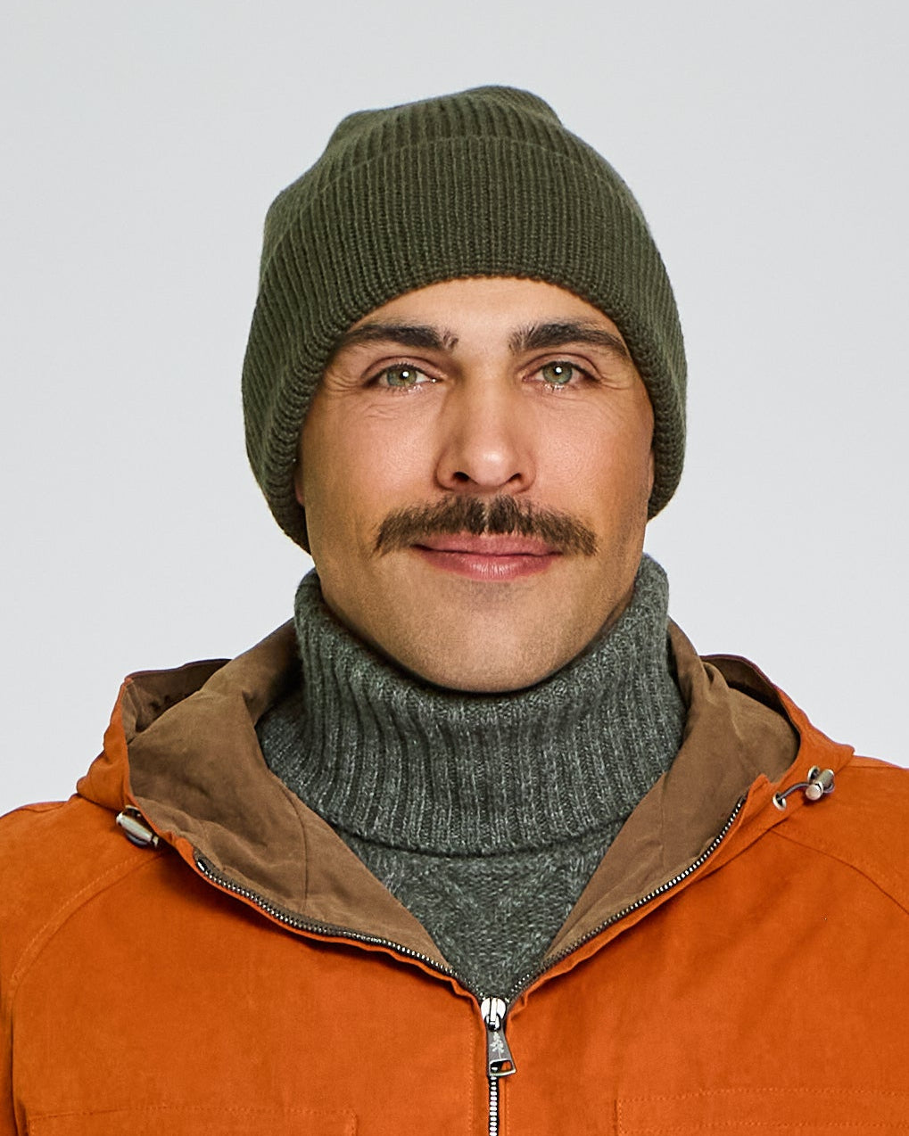 Man wearing an orange jacket with a hood on a plain background