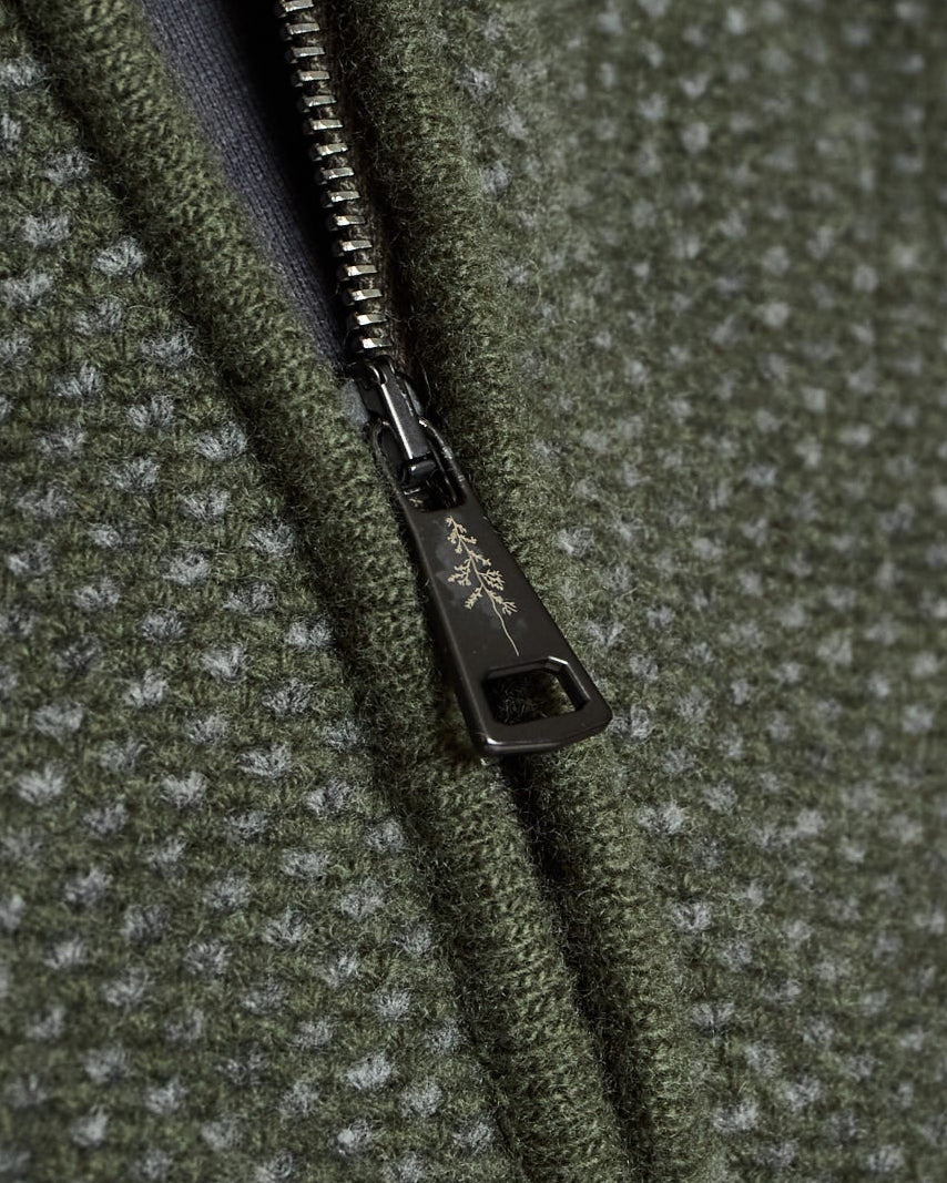 Close-up of a green textured fabric with a zipper