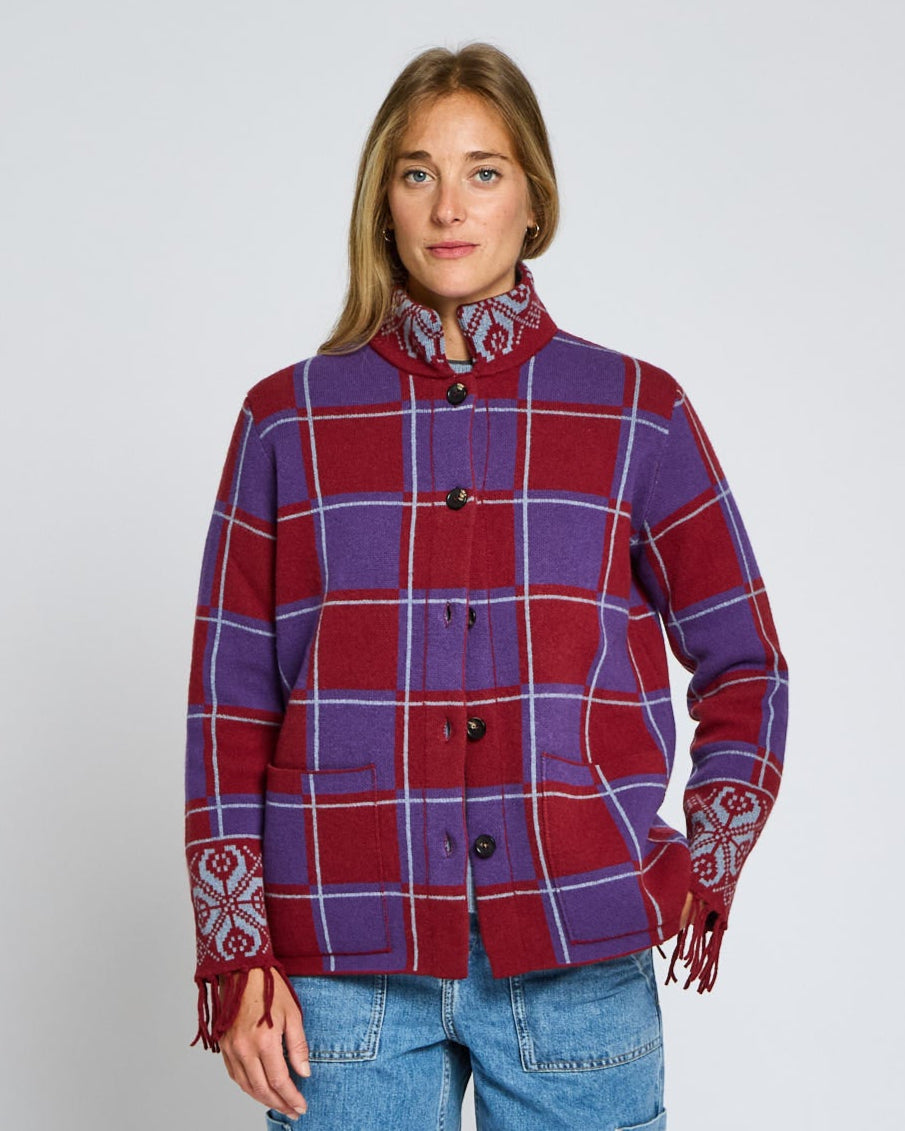 Person wearing a red and blue plaid jacket with a white background