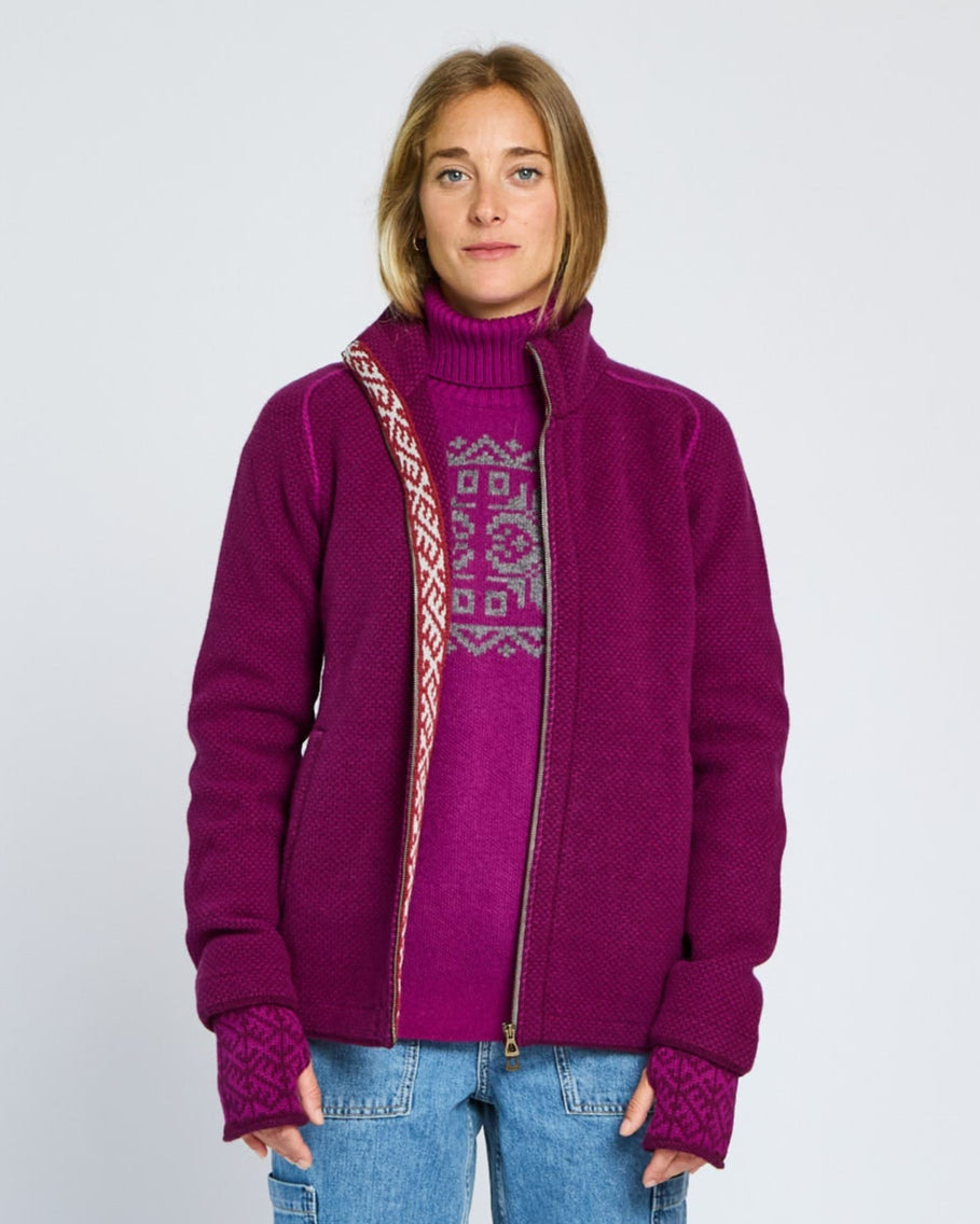 Person wearing a purple jacket with a patterned design on a plain background