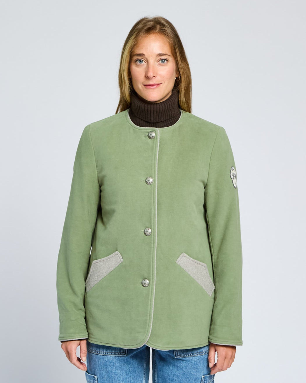 Person wearing a green jacket with a white background