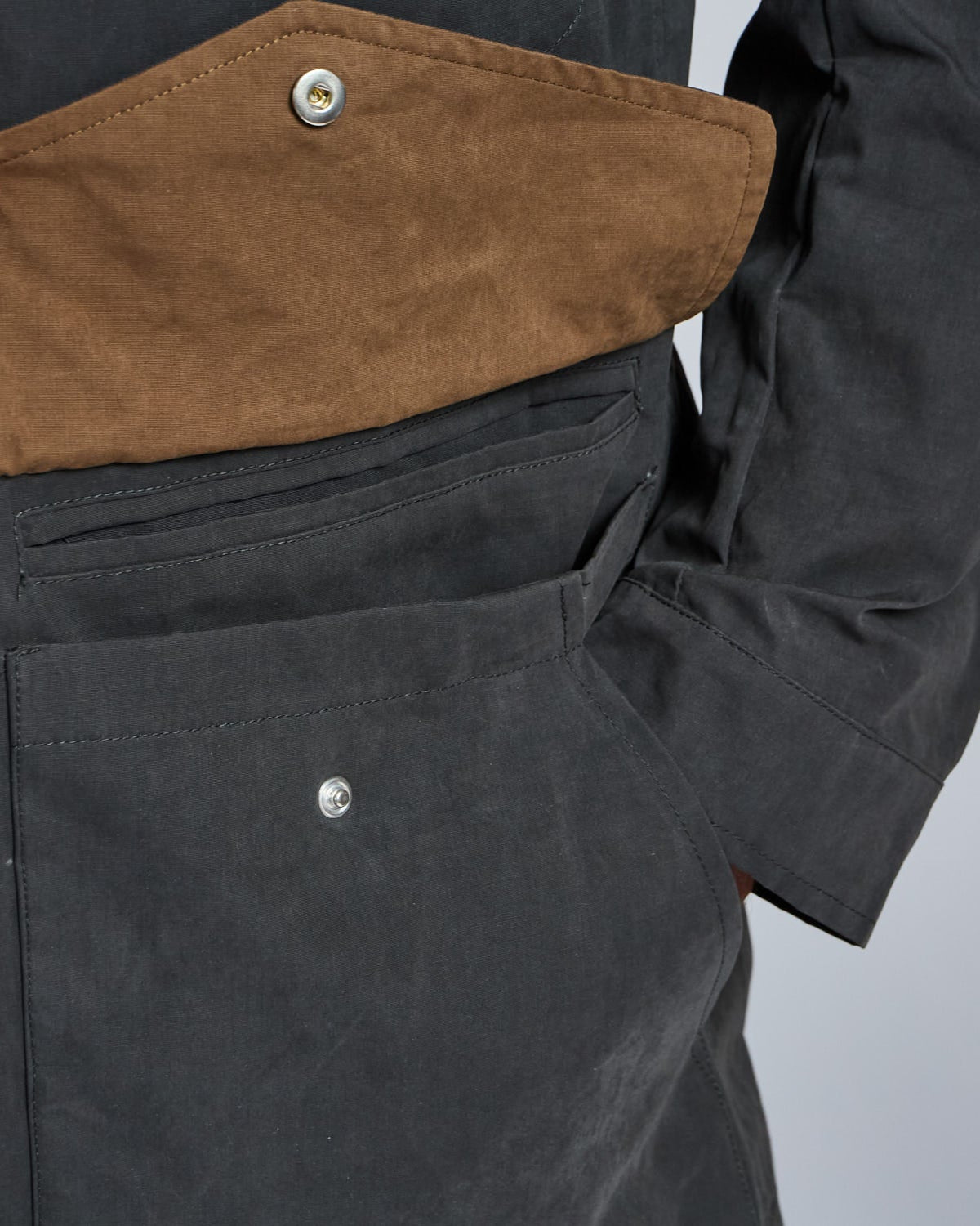Close-up of a black jacket with brown lining on a gray background