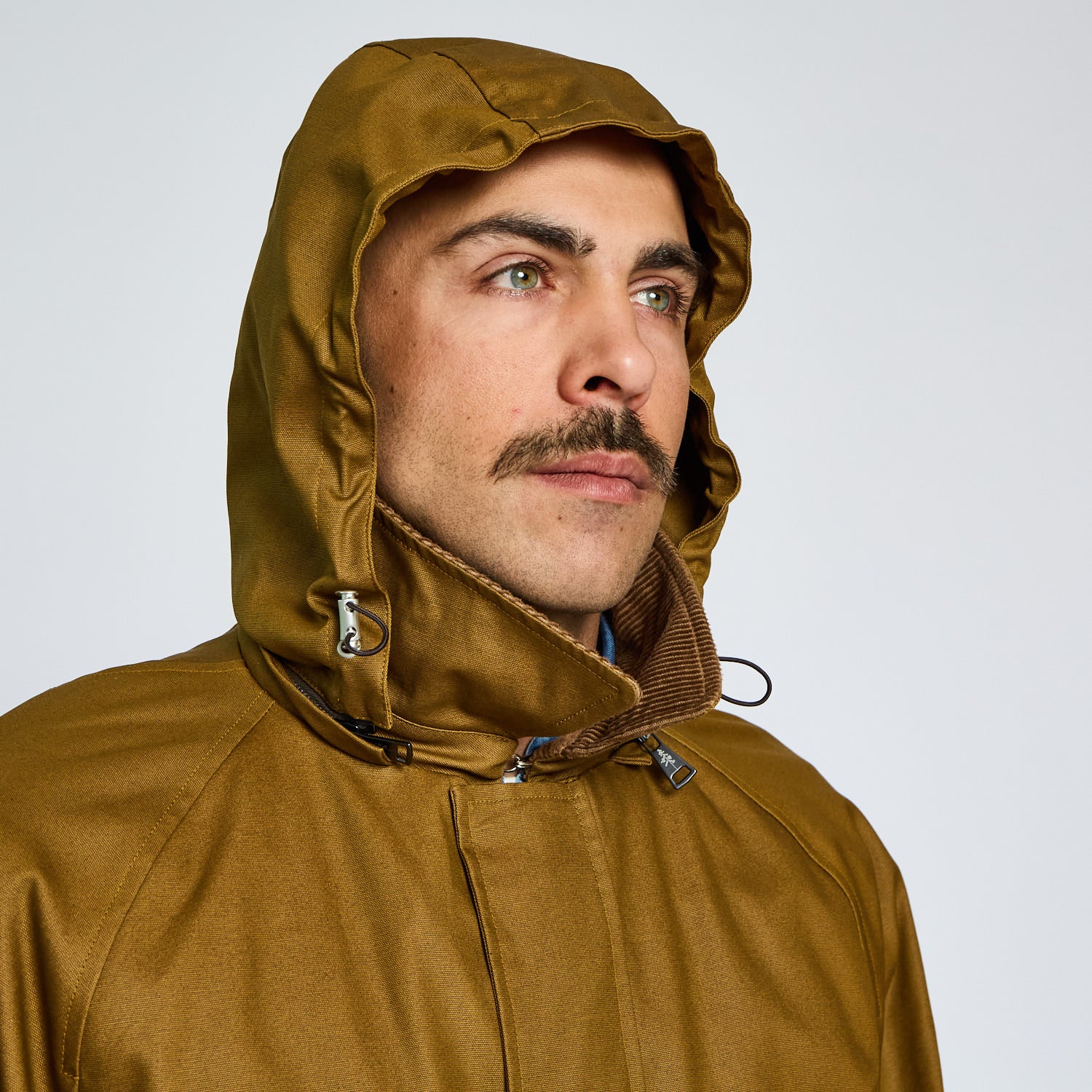 Man wearing a brown hooded jacket against a white background