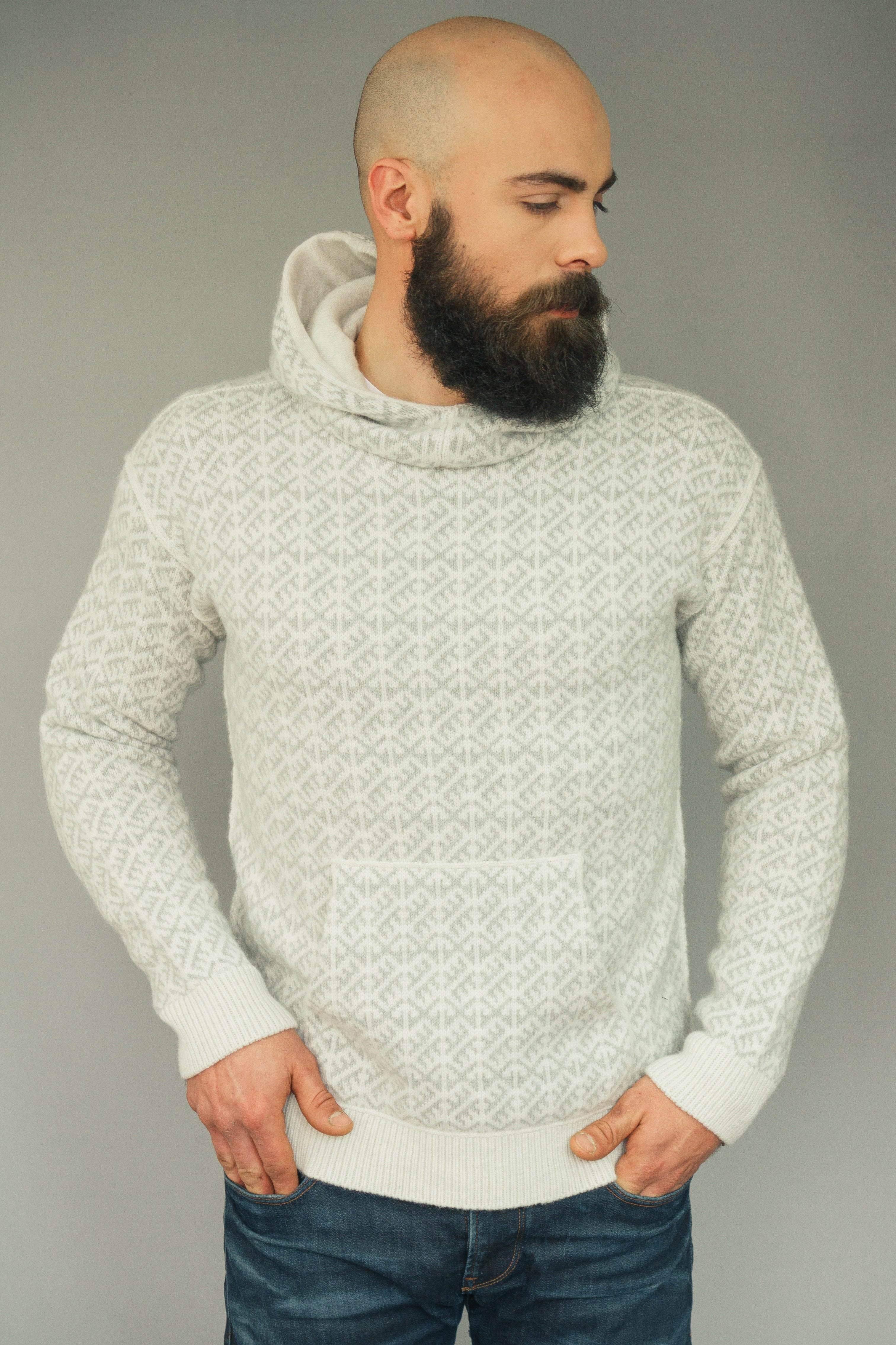 Man wearing a patterned sweater against a plain background